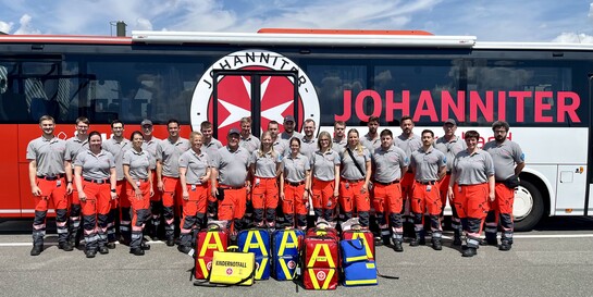 Ein Nothilfeteam der Johanniter steht vor einem Bus 