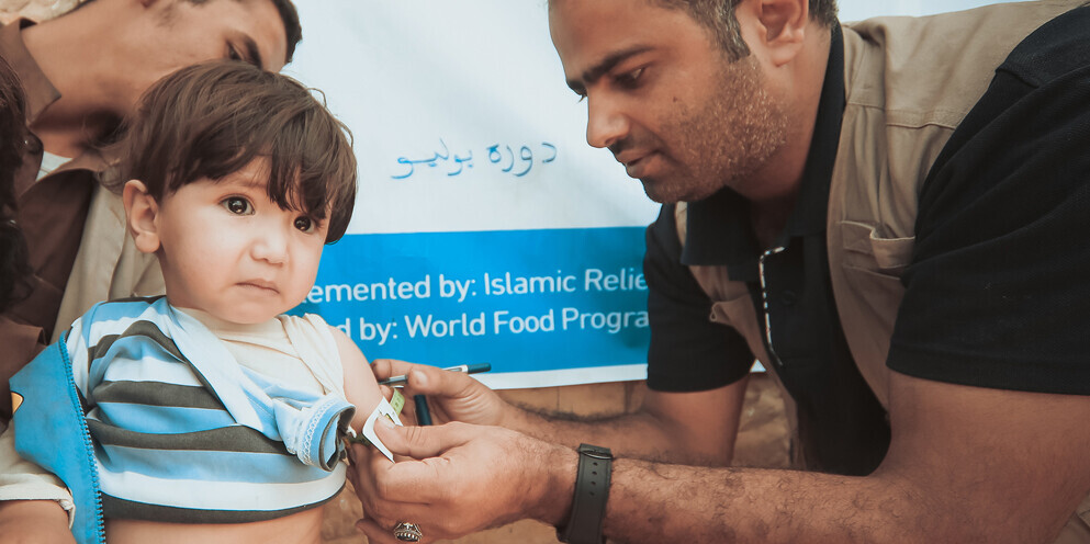 Ein Helfer prüft den Arm eines Kindes im Jemen