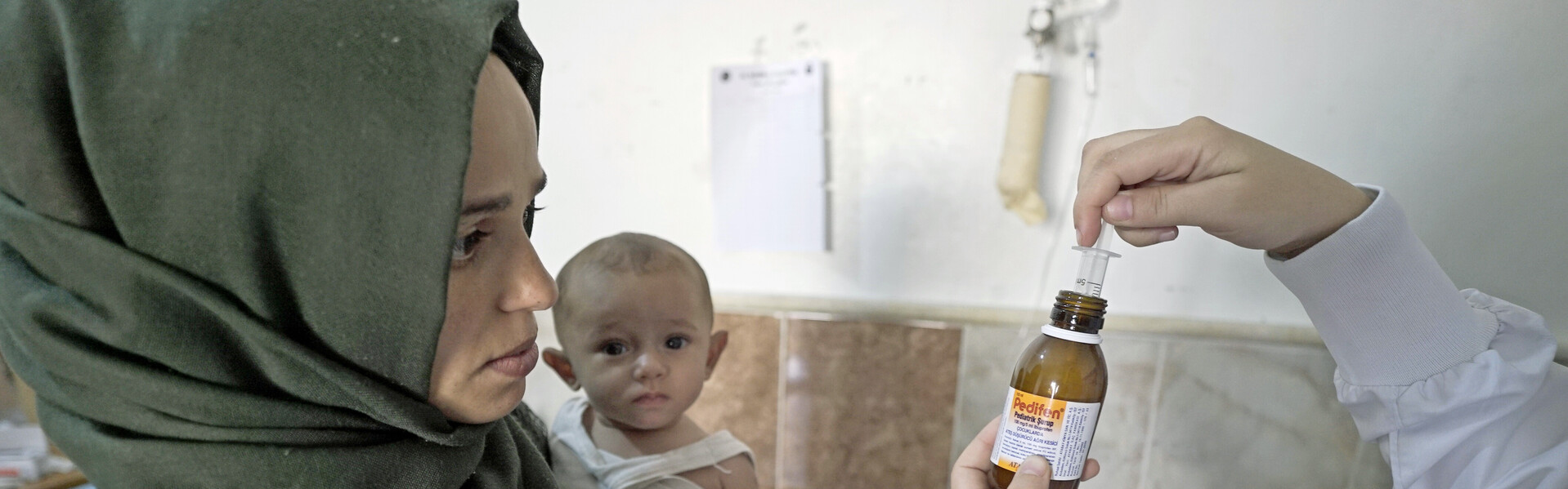 Eine syrische Frau mit Baby wird in einem Krankhaus medizinisch versorgt