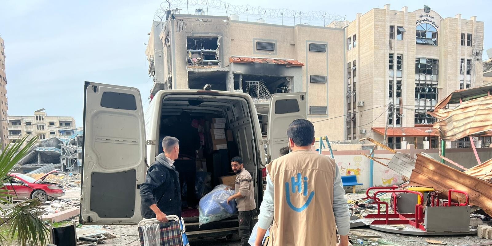 Helfer von Handicap International entladen Hilfsgüter aus einem Transporter