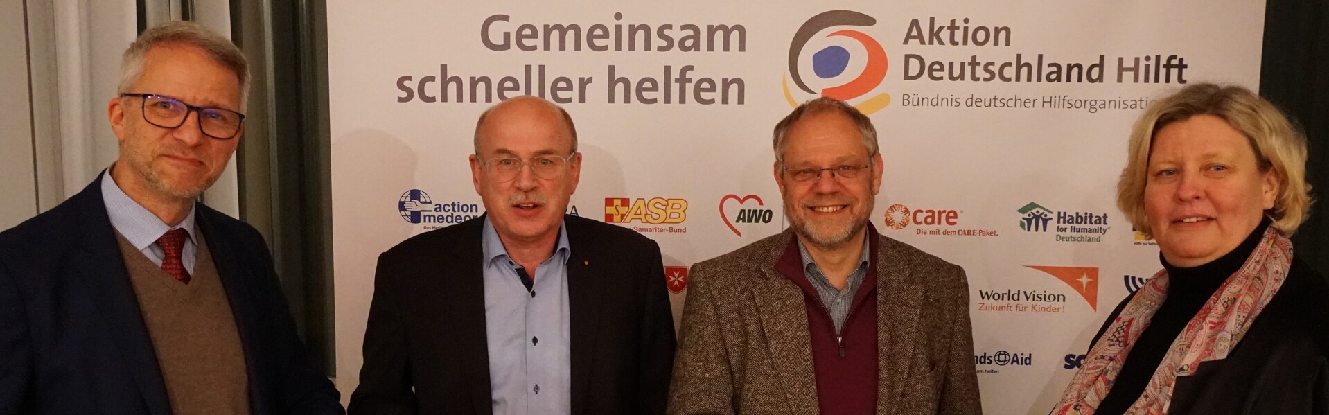 Mit dem Staffelstab übergeben Vorsitzende von Vorstand und Aufsichtsorgan von Aktion Deutschland Hilft ihre Ämter symbolisch an ihre Nachfolge 