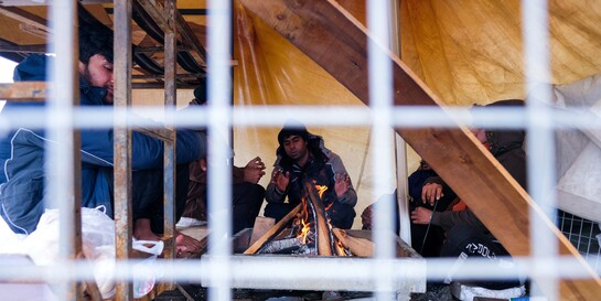 Flüchtlingslager Lipa: Flüchtlinge in einem Zelt wärmen sich an einem offenen Feuer, Copyright: Help - Hilfe zur Selbsthilfe/Bosnien