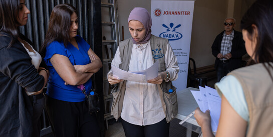 Eine Helferin der Organisation Nabaa organisiert im Libanon die Verteilung von Hilfsgütern für geflüchtete Menschen 
