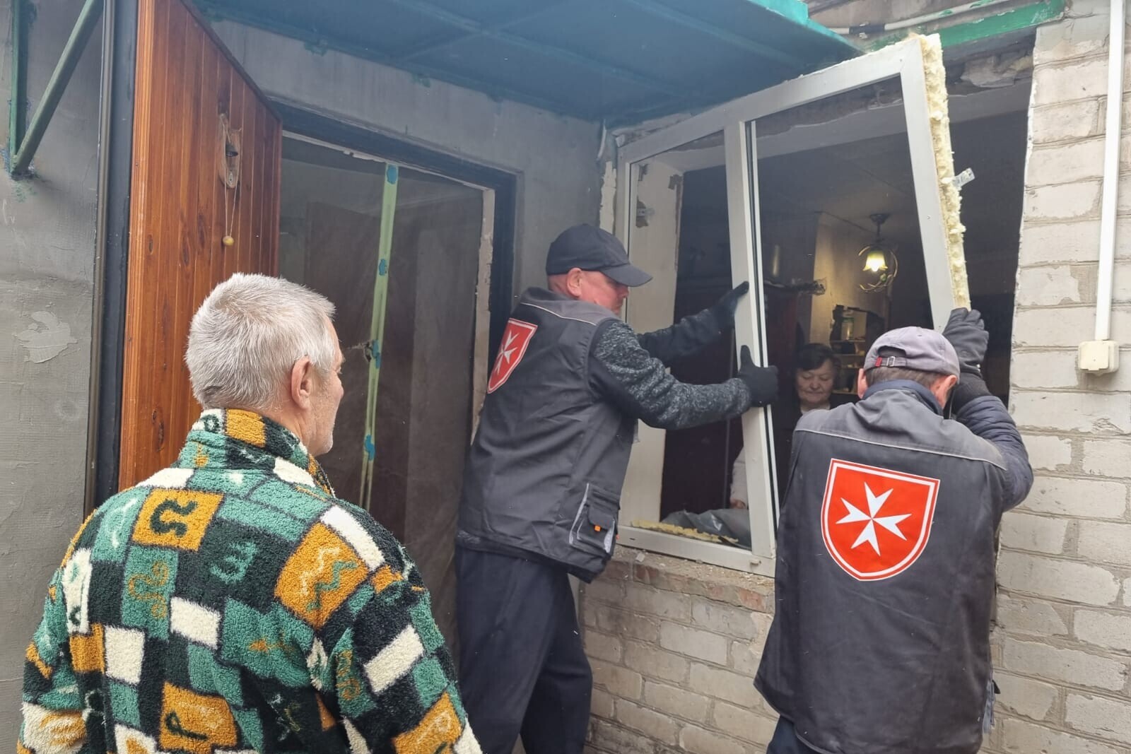 Helfer machen ein Haus in der Ukraine winterfest