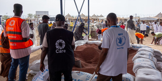 Drei Helfer:innen von CARE verteilen Lebensmittel an Vertriebene im Sudan