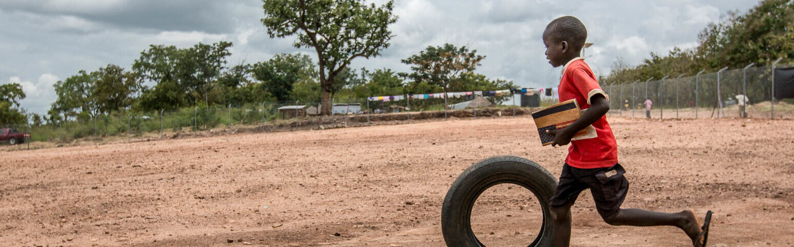Ein Kind aus dem Südsudan ist endlich in Sicherheit und spielt in einem Flüchtlingscamp in Uganda