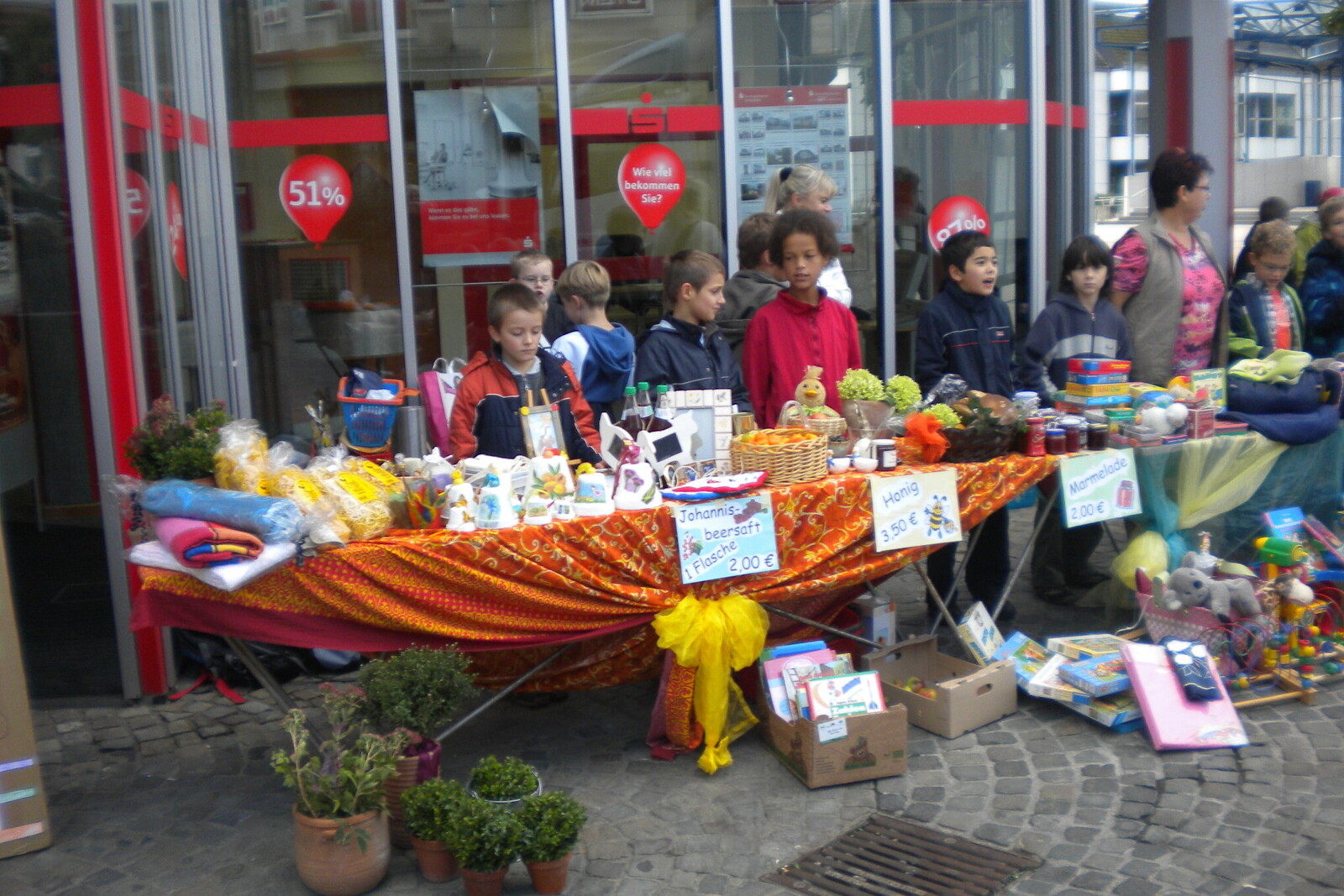Kinder verkaufen bei einem Flohmarkt Bücher und Spielsachen für einen guten Zweck.
