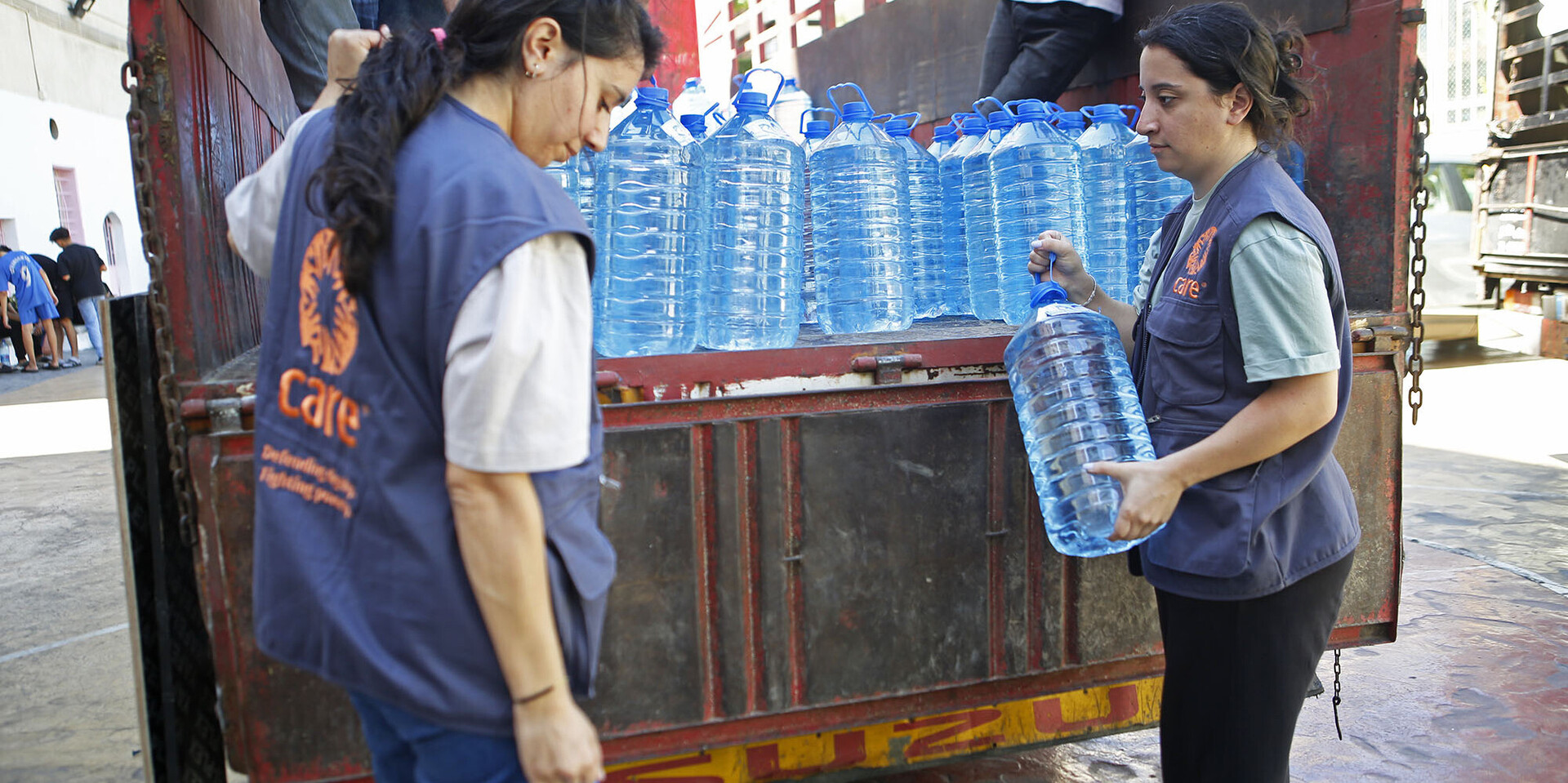 Zwei Helferinnen von CARE verteilen im Libanon sauberes Trinkwasser Zwei Helferinnen von CARE verteilen im Libanon sauberes Trinkwasser