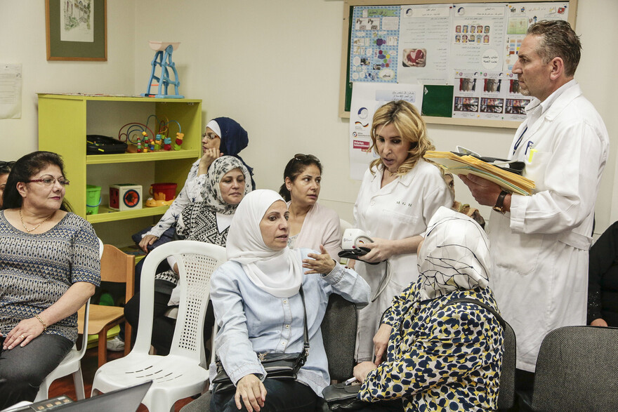 Eine Gruppe von Frauen im Libanon mit zwei Helfer:innen bei einer Aufklärungsveranstaltung zum Thema Gesundheit Eine Gruppe von Frauen im Libanon mit zwei Helfer:innen bei einer Aufklärungsveranstaltung zum Thema Gesundheit