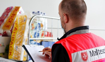 Ein Helfer im Flutgebiet mit Hygieneartikeln