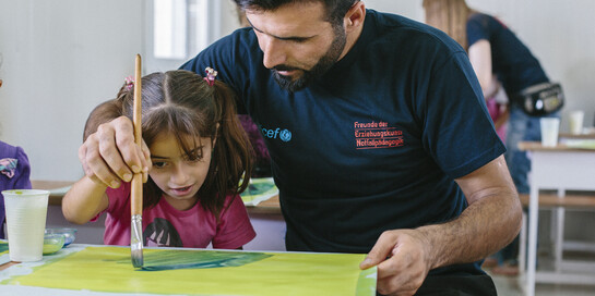 Hilfsprojekt im Nordirak: Helfer malt mit einem Mädchen Hilfsprojekt im Nordirak: Helfer malt mit einem Mädchen