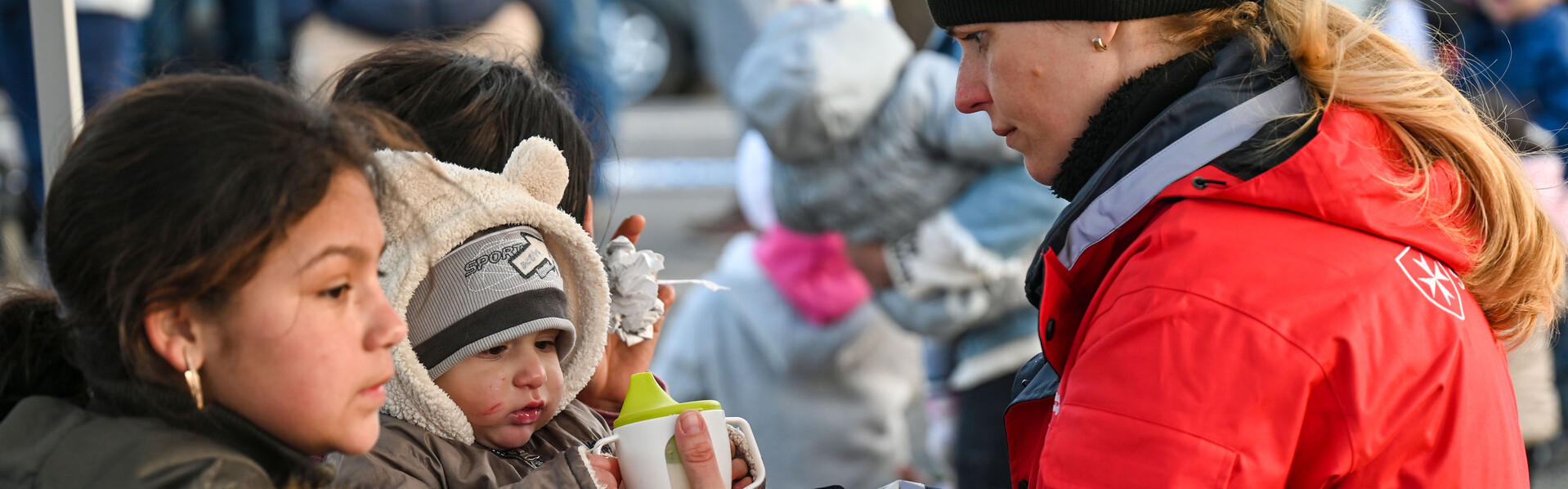 Eine Helferin von den ungarischen Maltesern versorgt geflüchtete Kinder aus der Ukraine  