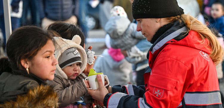 Helferin der Malteser versorgt ein Baby aus der Ukraine 