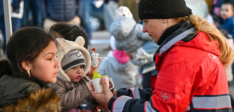 Helferin der Malteser versorgt ein Baby aus der Ukraine Helferin der Malteser versorgt ein Baby aus der Ukraine