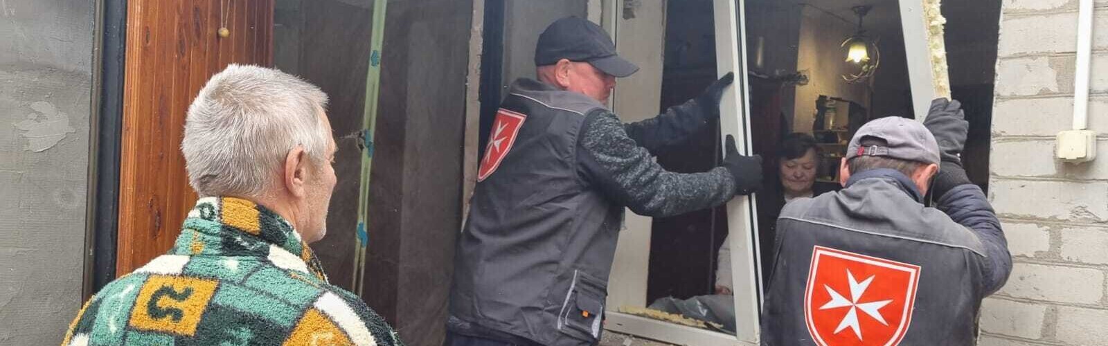 Helfer der Malteser bauen in der Ukraine neue Fenster in Häuser ein