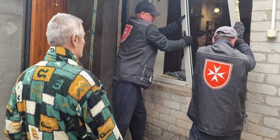 Helfer der Malteser bauen in der Ukraine neue Fenster in Häuser ein