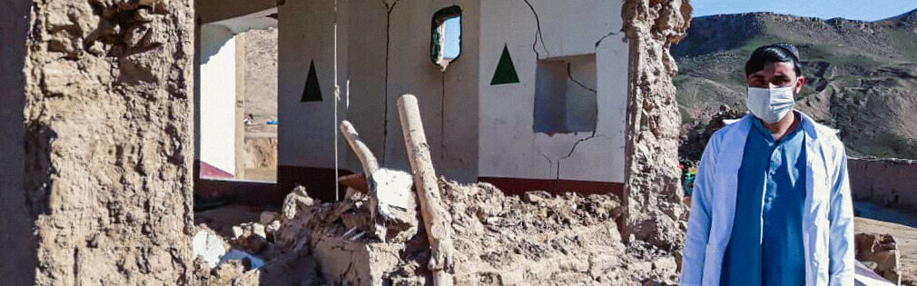 Ein Mann vor einem zerstörten Haus nach einem Erdbeben Anfang 2022 in Afghanistan 