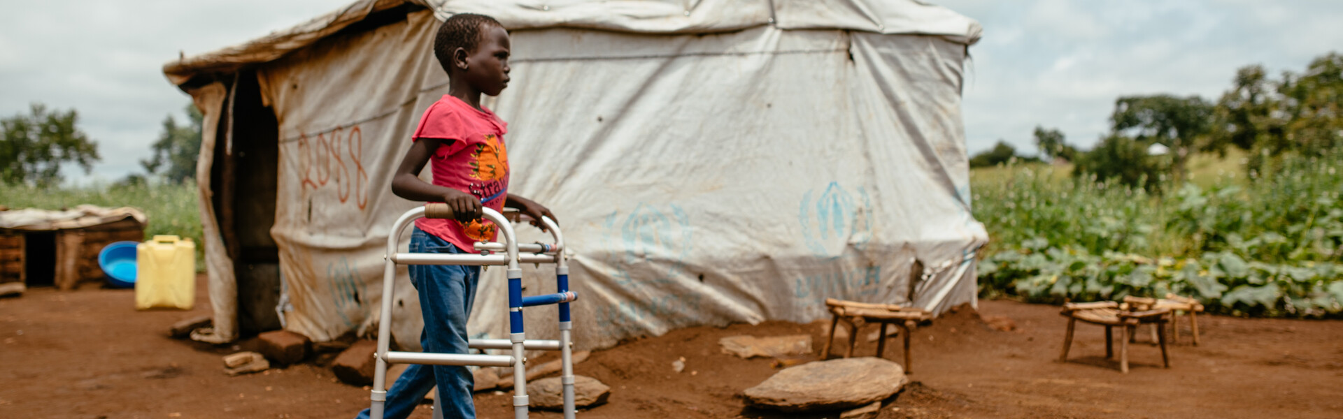 Ein Junge mit einer Gehhilfe in einem Camp in Uganda
