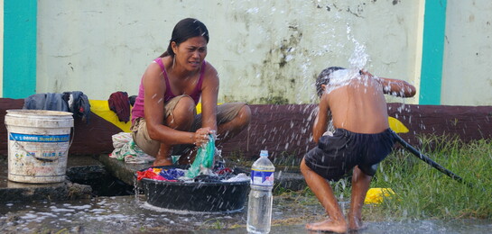 Nach Taifun Haiyan auf den Philippinen ist sauberes Wasser besonders wichtig, um Krankheiten zu vermeiden. Eine Frau und ihr Kind waschen Kleidung.