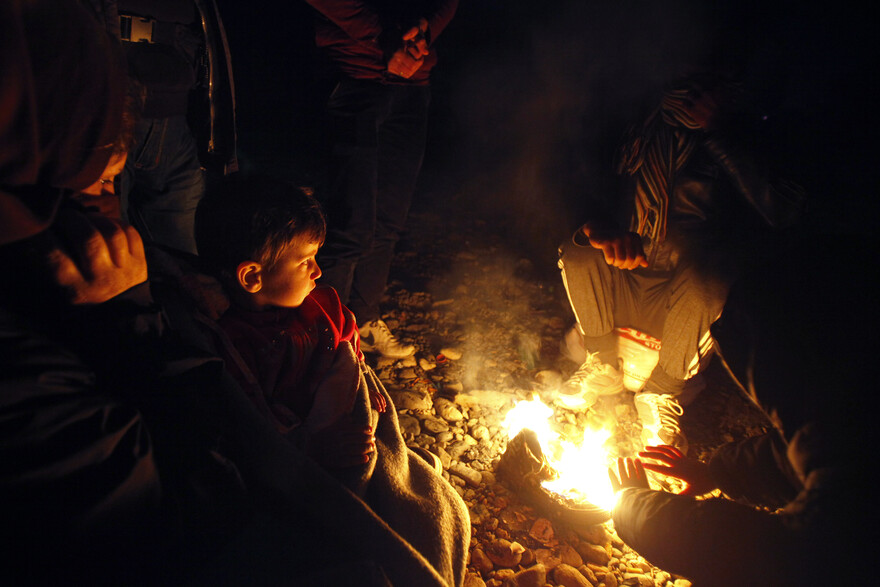Menschen wärmen sich am Feuer Menschen wärmen sich am Feuer