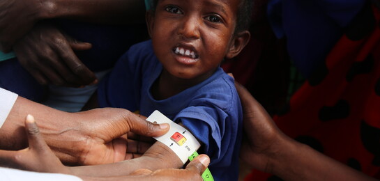 Ein Kind wird in Afrika der Arm gemessen. Es leidet unter der Hungersnot in Afrika