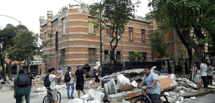 In Mexiko verwüstete ein Erdbeben viele Häuser. Menschen stehen vor einer Häuserruine. In Mexiko verwüstete ein Erdbeben viele Häuser. Menschen stehen vor einer Häuserruine.