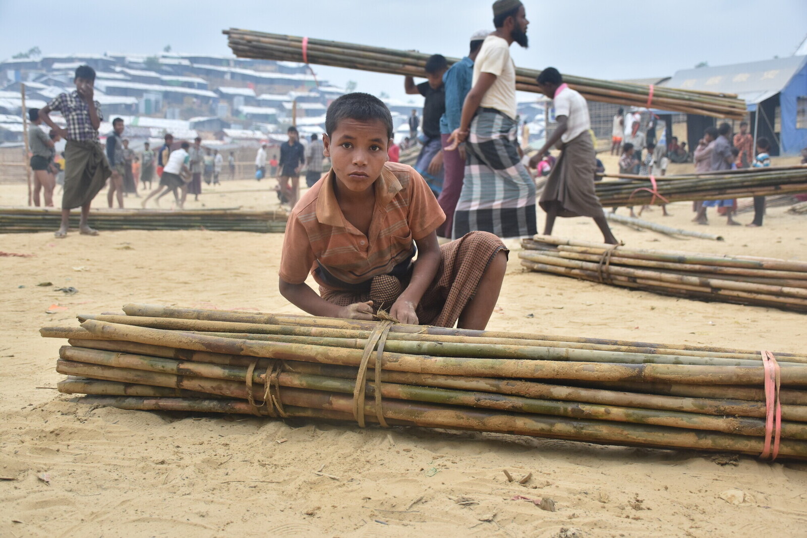 Ein Junge bindet Bambusstäbe 