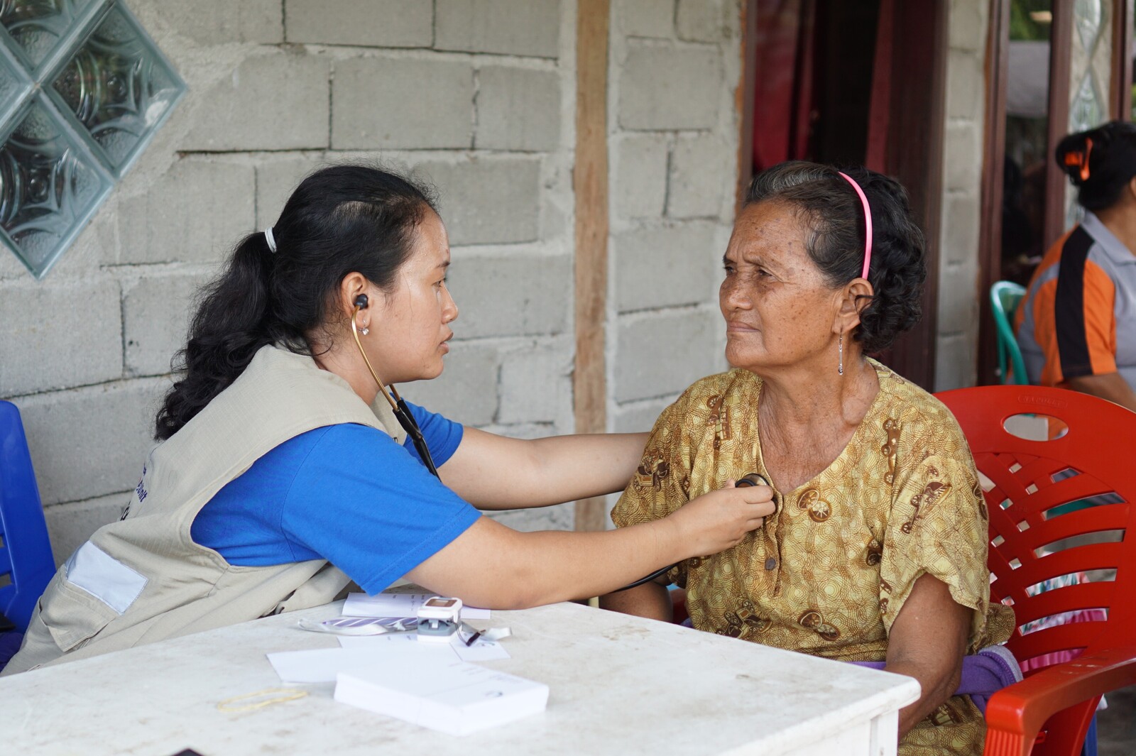 Eine ältere Frau in Indonesien wird von einer Ärztin untersucht