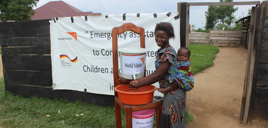 Eine Mutter wäscht sich die Hände an einer Station von World Vision im Kongo.