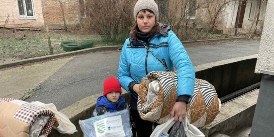 Eine Frau und ihr Sohn in der Ukraine erhalten Hilfsgüter von der Organisation arche noVa