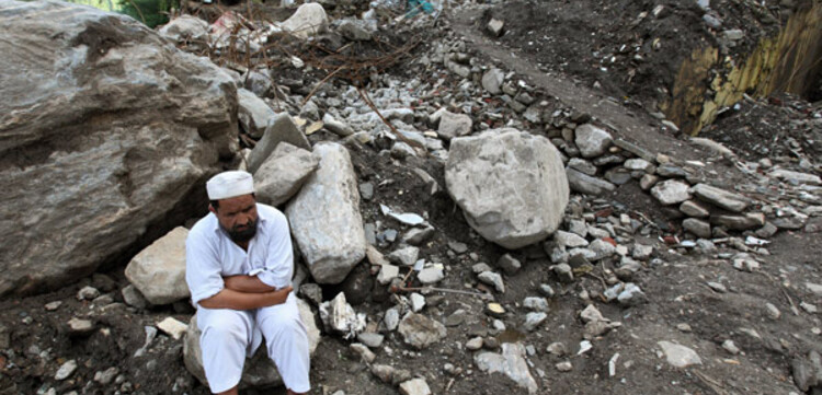 Flut Pakistan: Mann sitzt auf Bergen von Schutt Flut Pakistan: Mann sitzt auf Bergen von Schutt
