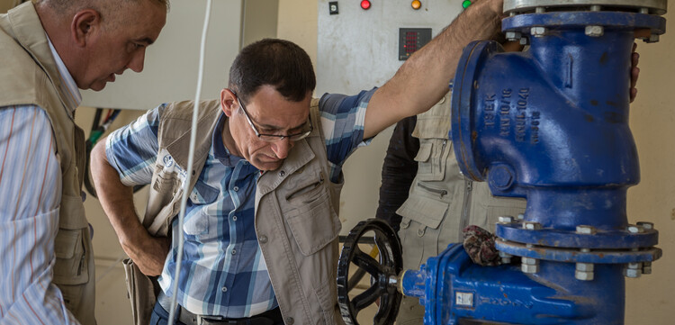 Ein Mitarbeiter von arche noVa kontrolliert eine Wasserpumpe in einem Flüchtlingscamp im Irak