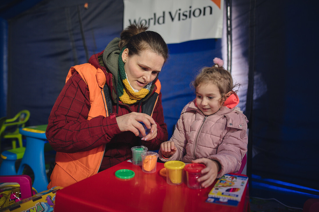 Eine Helferin von World Vision in einem geschützten Raum für Kinder Eine Helferin von World Vision in einem geschützten Raum für Kinder