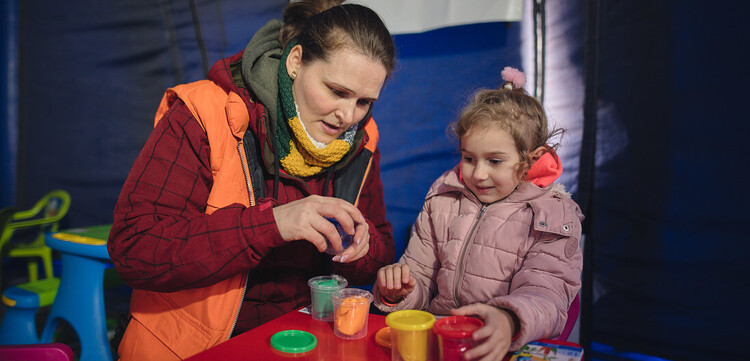 Eine Helferin von World Vision in einem geschützten Raum für Kinder Eine Helferin von World Vision in einem geschützten Raum für Kinder