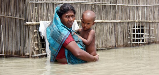 Eine Mutter hält ihr Kind im Hochwasser in den Armen