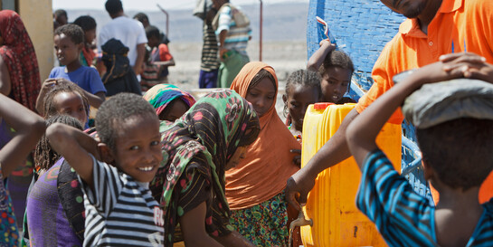 Kinder und Frauen an einem Wasserkanister in Äthiopien