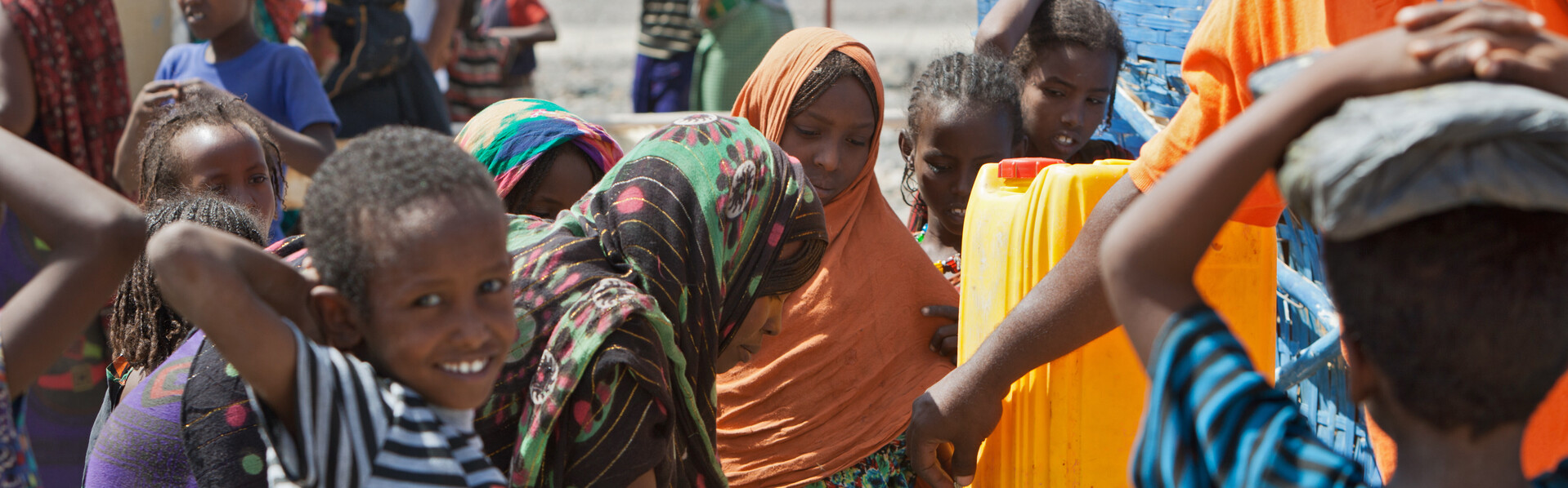 Kinder und Frauen an einem Wasserkanister in Äthiopien