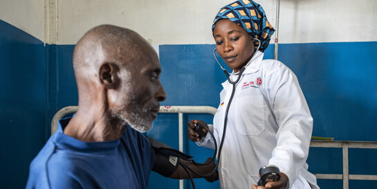 Eine Helferin untersucht einen älteren Mann in der DR Kongo
