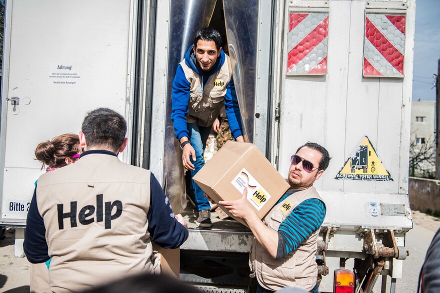 Mitarbeiter einer Hilfsorganisation entladen Versorgungspakete für syrische Flüchtlinge Mitarbeiter einer Hilfsorganisation entladen Versorgungspakete für syrische Flüchtlinge
