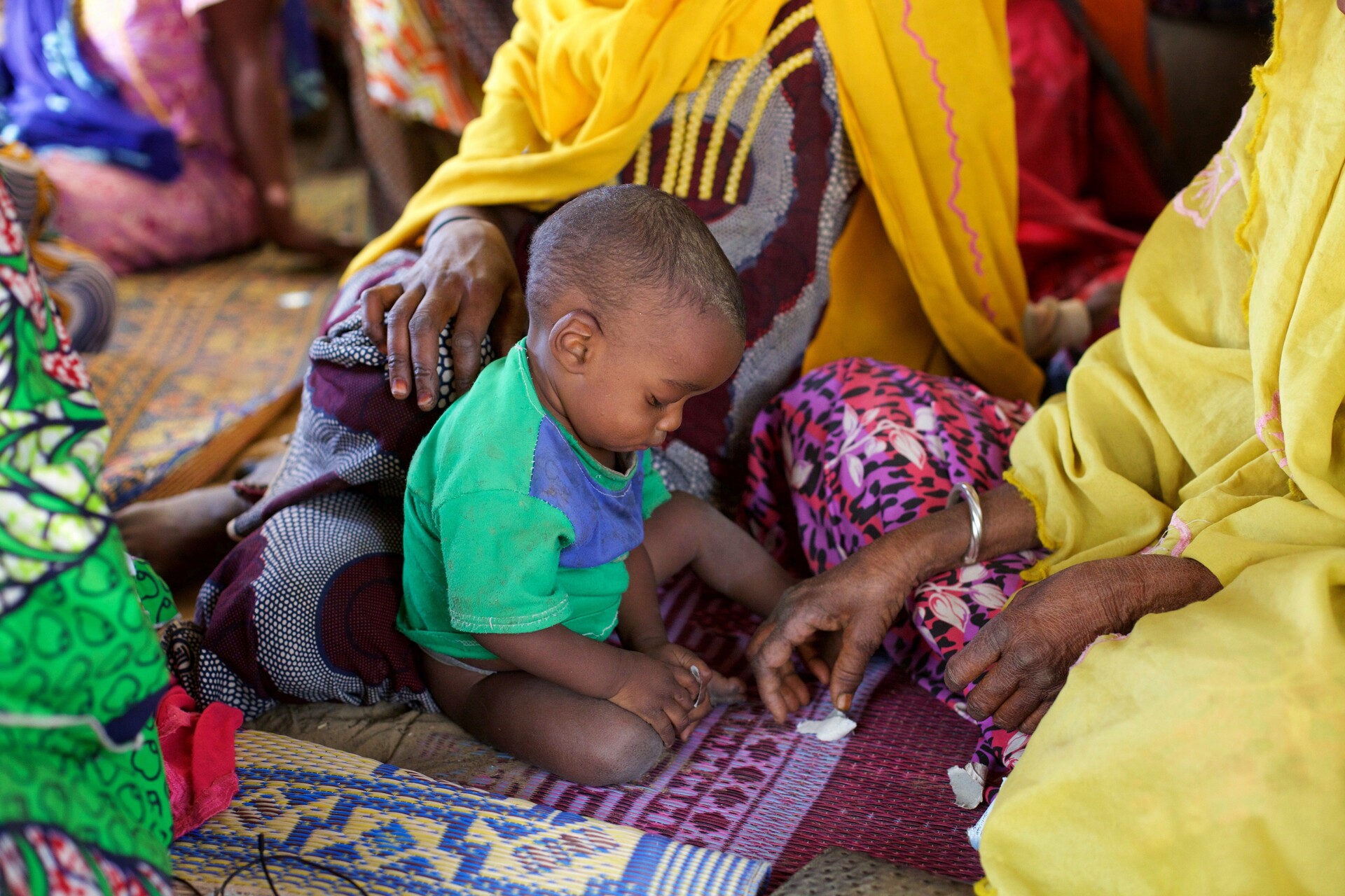 Ein Kind im Osten von Niger sitzt auf dem Boden. Ein Kind im Osten von Niger sitzt auf dem Boden.