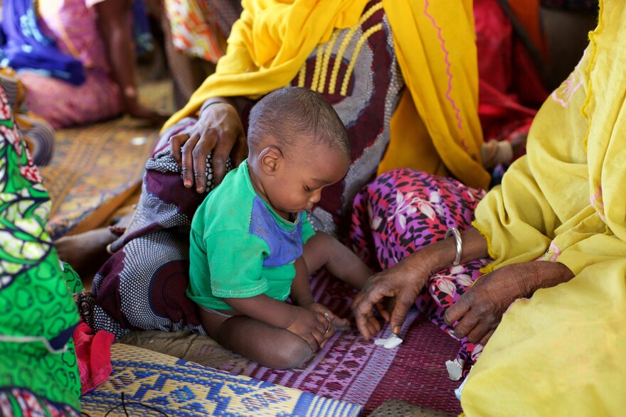 Ein Kind im Osten von Niger sitzt auf dem Boden. Ein Kind im Osten von Niger sitzt auf dem Boden.