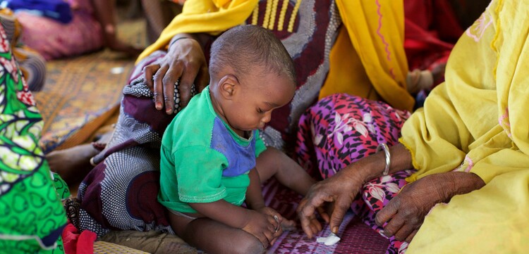 Ein Kind im Osten von Niger sitzt auf dem Boden. Ein Kind im Osten von Niger sitzt auf dem Boden.