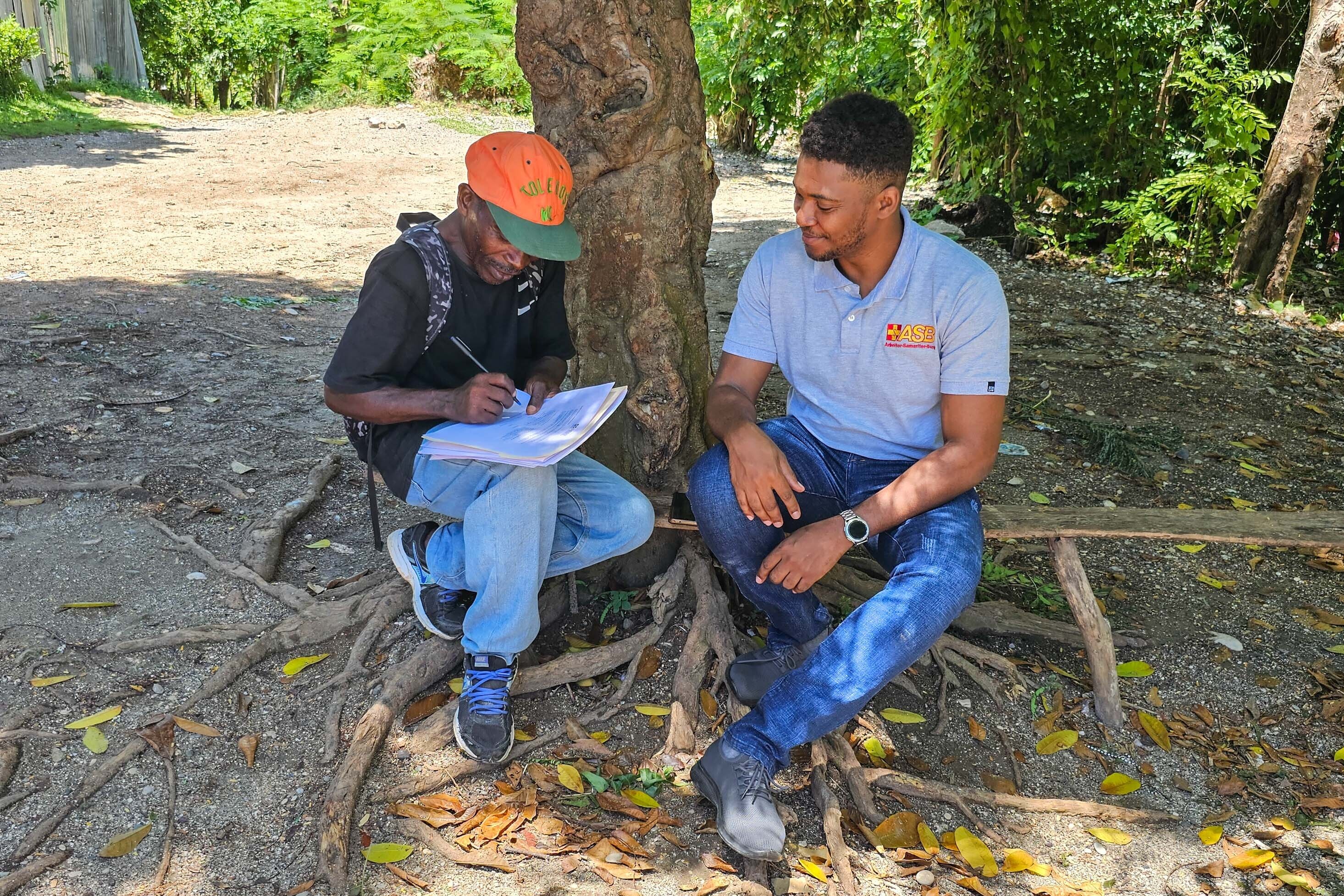 Ein Mitarbeiter vom ASB wird in Haiti von einem Mann interviewt Ein Mitarbeiter vom ASB wird in Haiti von einem Mann interviewt