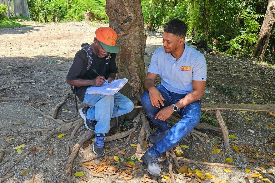 Ein Mitarbeiter vom ASB wird in Haiti von einem Mann interviewt Ein Mitarbeiter vom ASB wird in Haiti von einem Mann interviewt