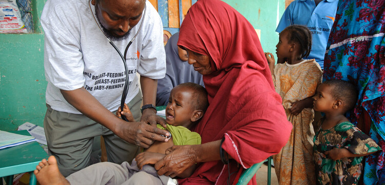 Ein Mitarbeiter von World Vision untersucht ein Kleinkind in einem Dorf in Somalia