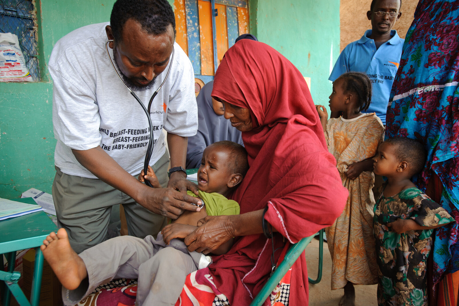Ein Mitarbeiter von World Vision untersucht ein Kleinkind in einem Dorf in Somalia