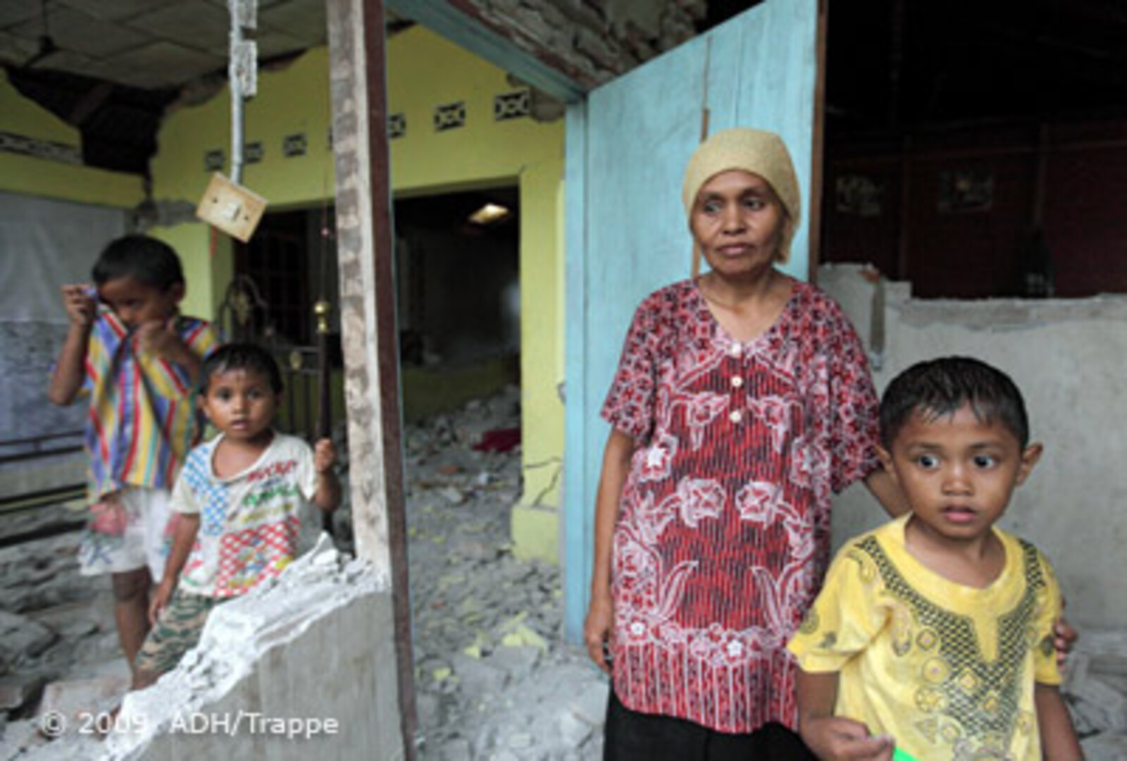 Katastrophen Südostasien: Frau mit ihren Kindern im zerstörten Haus