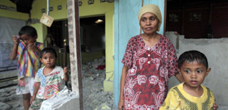 Katastrophen Südostasien: Frau mit ihren Kindern im zerstörten Haus