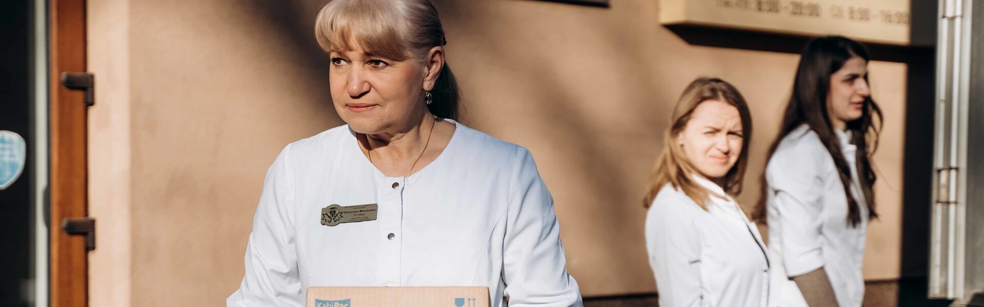 Eine Helferin hält in der Ukraine ein Paket mit Hilfsgütern in der Hand