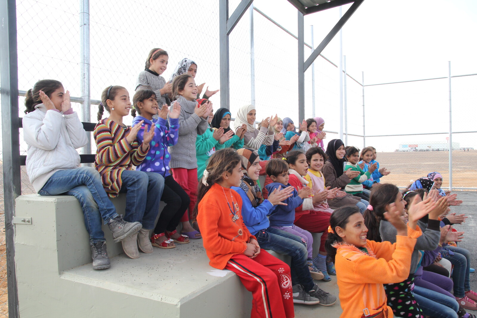 Im Camp Azraq sitzen Flüchtlingskinder im Publikum und applaudieren den Fußballspielern.